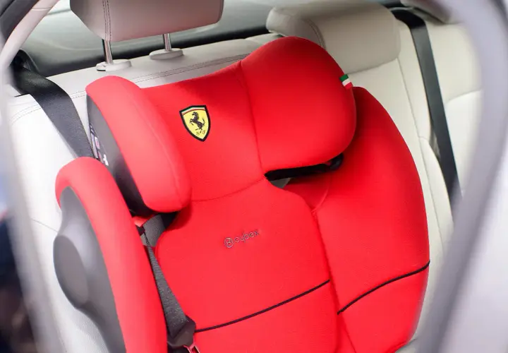 Czerwony fotelik samochodowy Cybex z logo Ferrari, gotowy do montażu. Instrukcja jak zamontować fotelik w samochodzie.