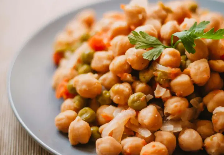 Plato de garbanzos guisados con guisantes y zanahoria, perfecto para una receta saludable.
