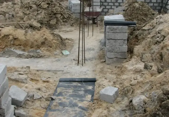 Budowa w toku: zbrojenie, bloczki, ziemia i warstwa chudego betonu przygotowana pod fundamenty.