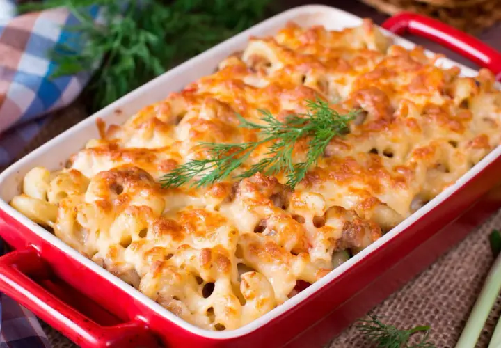 Un plat de pâtes au four gratinées, garni d'une touche d'aneth frais. Un délice réconfortant prêt à être dégusté.