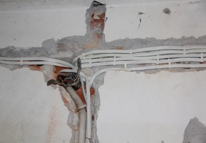 Nowe przewody elektryczne w ścianie, przygotowanie do wymiany instalacji elektrycznej.