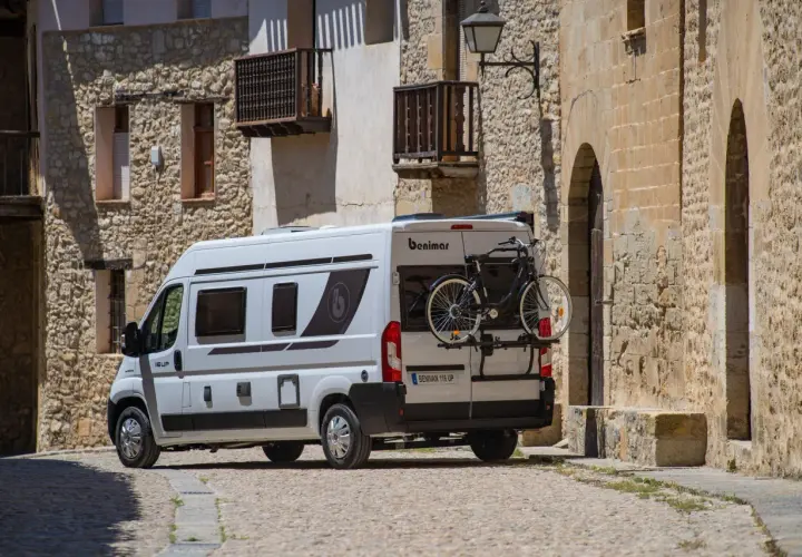 Furgoneta blanca con portabicicletas trasero, mostrando cómo llevar la bici dentro de la furgoneta para aventuras.