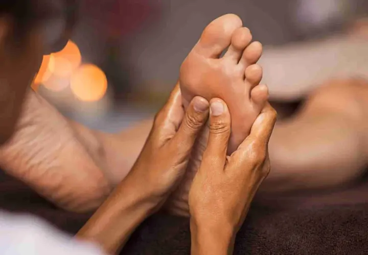 Mani esperte eseguono un rilassante foot massage, sciogliendo tensioni e donando benessere.