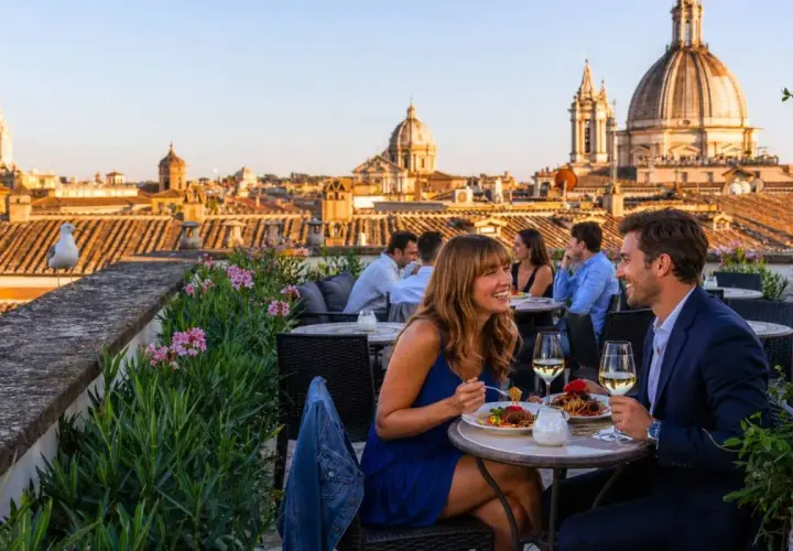 Coppia felice cena in uno dei ristoranti con vista Roma, con cupole e tetti all'orizzonte.
