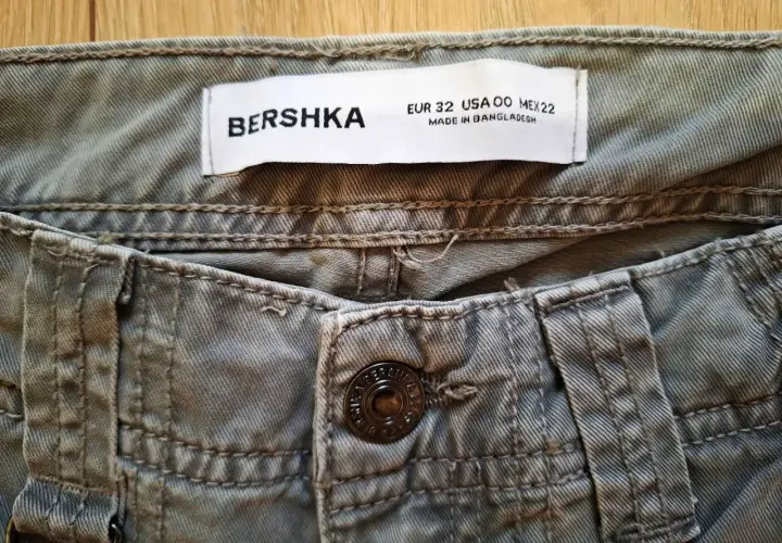 Metka z metrażem Bershka EUR 32, USA 00, MEX 22. Tabela rozmiarów Bershka pomoże Ci wybrać idealne spodnie.