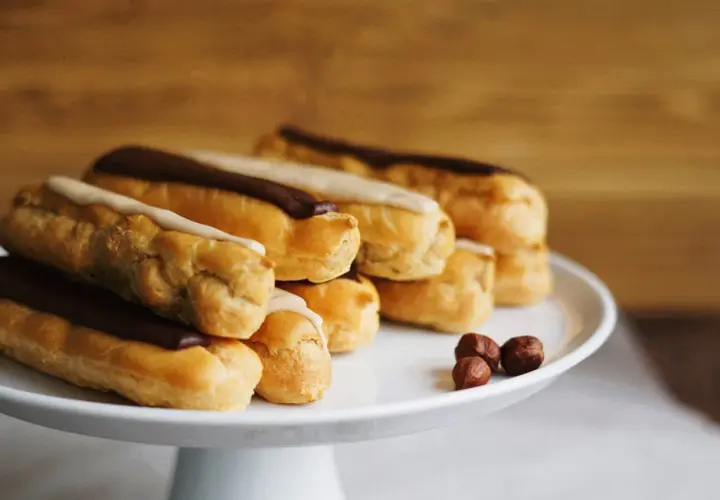 Una pila di éclair con glassa al cioccolato e vaniglia, pronti per essere gustati. La ricetta perfetta per un dolce momento.