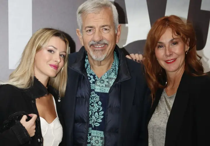 Carlos Sobera posa con sus hijos, una joven rubia y una mujer pelirroja, sonriendo a la cámara.