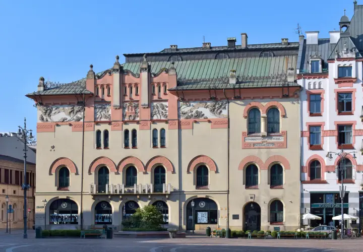 Elegancka fasada Teatru Starego w Krakowie z ozdobnymi detalami i łukowymi oknami.