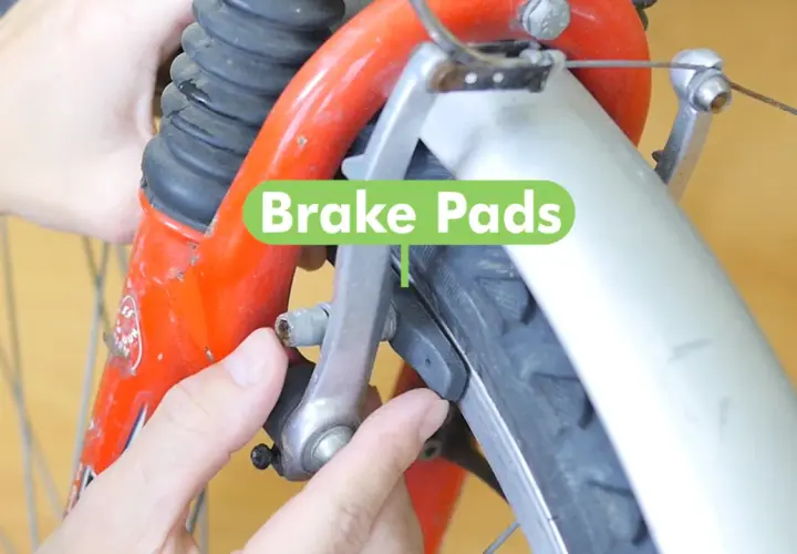 Hands adjusting bike brake pads. Learn how to fix a brake on a bike by ensuring these pads are properly aligned for safe stopping.