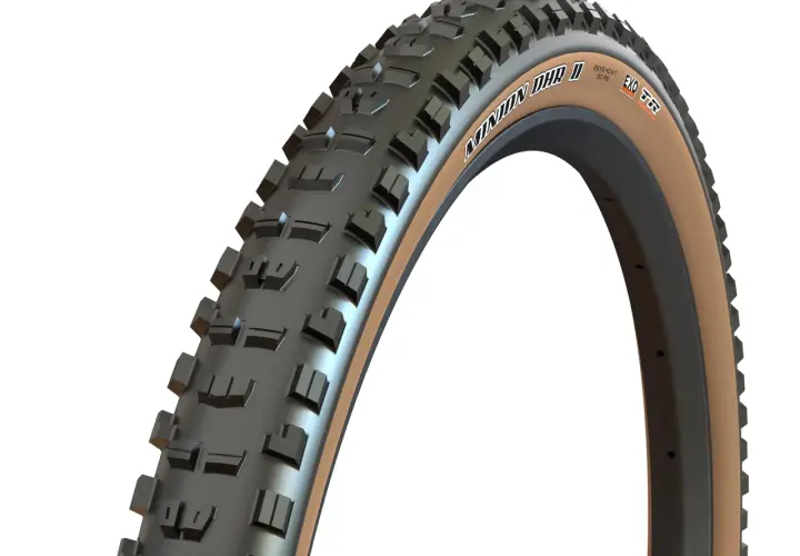 Close-up of a Maxxis Minion DHR II tire with tan sidewalls, ready for trail riding. Many riders praise these for their grip.