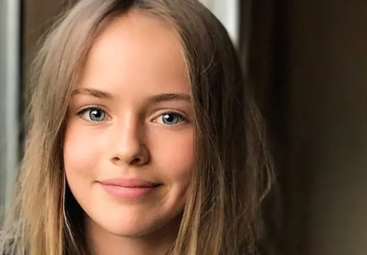 Uśmiechnięta dziewczyna o niebieskich oczach i blond włosach, która wygląda jak najładniejsza dziewczyna na świecie.