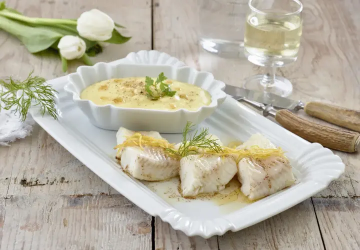 Elegancki halibut przepis: delikatne kawałki ryby z cytrynową skórką i koperkiem, podane z kremowym sosem. Idealne danie.