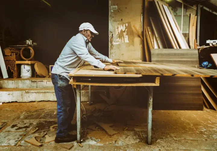Artisan ajustant des planches de bois. Si votre cuisine est mal posée, quel recours ?