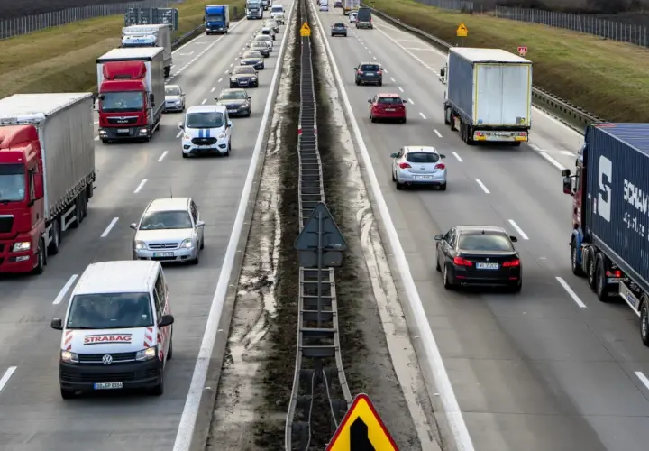 Ruch na autostradzie, gdzie wiele samochodów i ciężarówek jedzie w kierunku Wrocławia. Czy autostrada na Wrocław jest płatna?