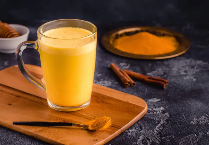 Goldene Kurkuma Milch mit Zimt und Honig. Die Kurkuma Milch Wirkung ist bekannt für ihre entzündungshemmenden Eigenschaften.