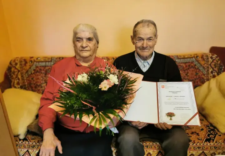 Para Genowefa i Jan Dziedzic świętuje 70 rocznicę ślubu. Otrzymują gratulacje i bukiet kwiatów.