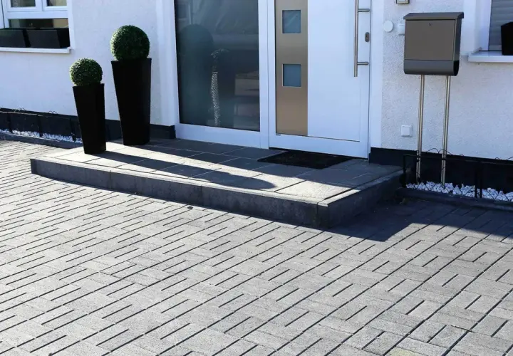 Nowoczesne aranżacje kostka brukowa wzory tworzą elegancki podjazd i schody przed domem.