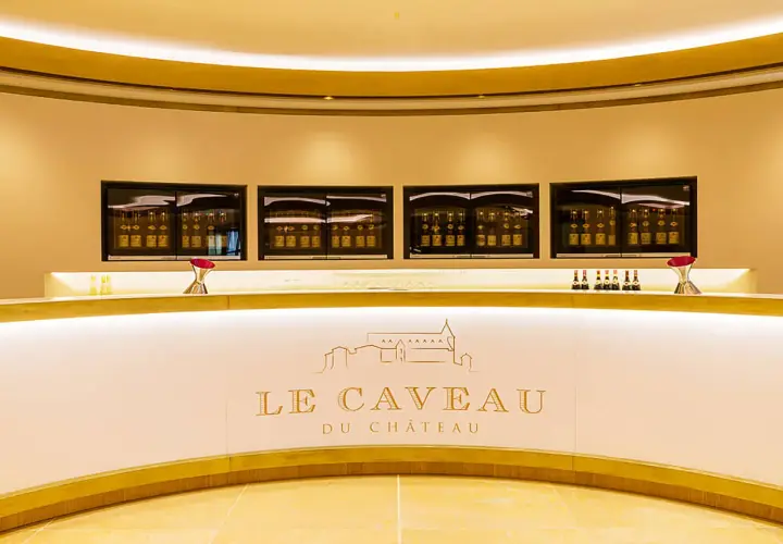 Le caveau Guigal, un comptoir moderne avec des bouteilles de vin exposées dans des vitrines lumineuses.