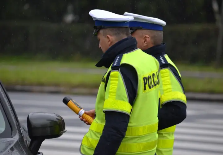 Policjant w kamizelce odblaskowej trzyma alkomat. Czy można odmówić dmuchania w alkomat? To pytanie zadaje sobie wielu kierowców.
