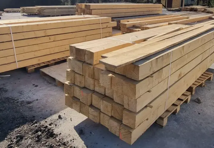 Stosy drewnianych belek, gotowe do transportu. Skład drewna machnik oferuje materiały budowlane najwyższej jakości.