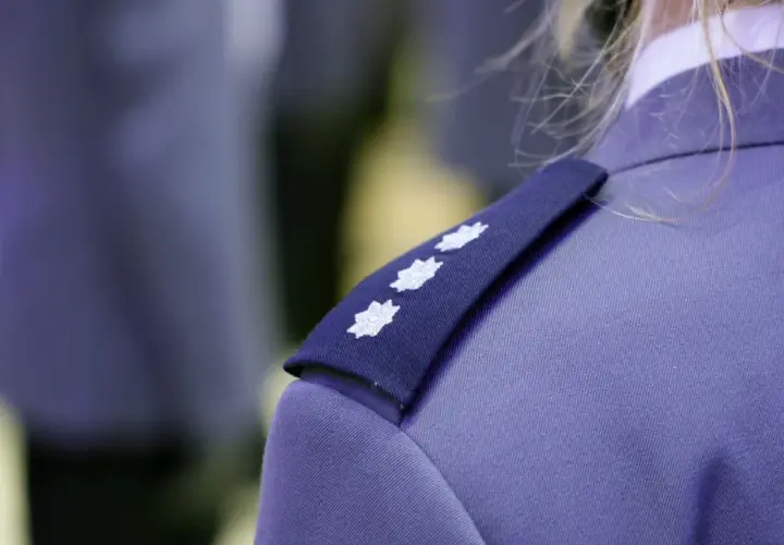Trzy białe gwiazdki na granatowym naramienniku munduru policyjnego. To jeden ze sposobów, by poznać, jakie są stopnie w policji.