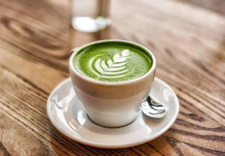 Tazza di matcha latte con schiuma decorata, un esempio di cos'è il latte in una bevanda cremosa e deliziosa.