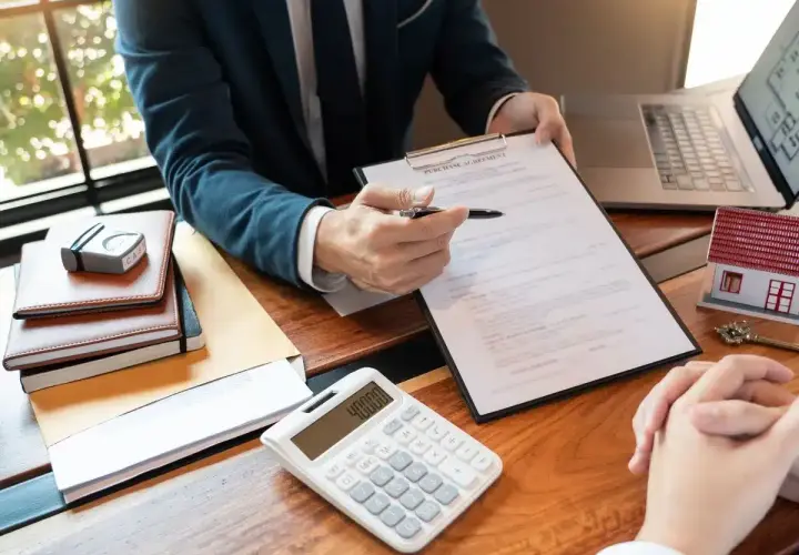 Biznesmen analizuje umowę kredytową, obok leży kalkulator z kwotą 40000.