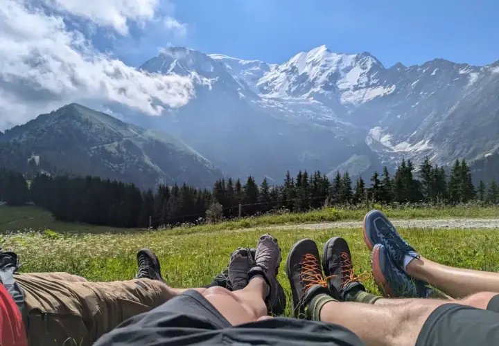 Odpoczynek po trudach Tour du Mont Blanc. Widok na ośnieżone szczyty i zielone doliny.