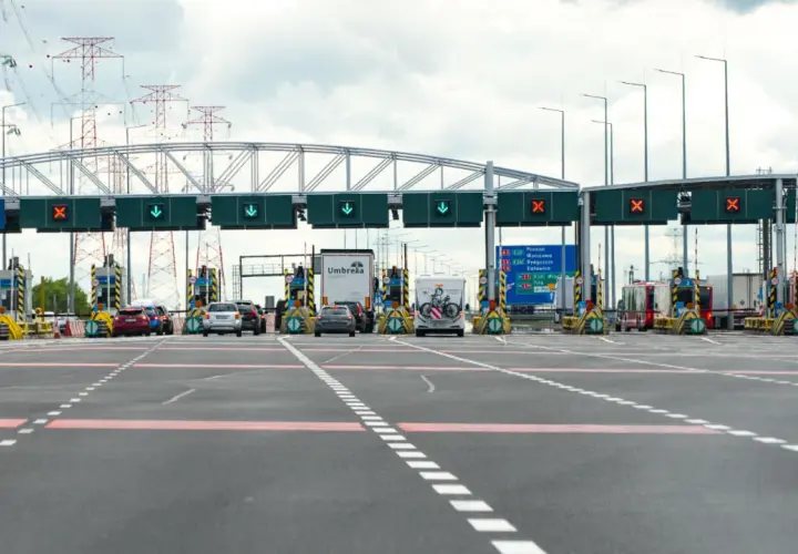 Bramki autostradowe, gdzie sprawdzisz, ile kosztuje autostrada do Zakopanego. W tle linie energetyczne.