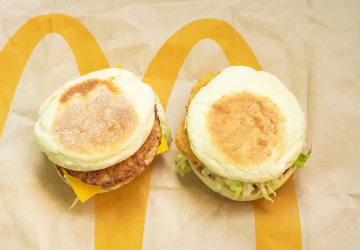Dwa McMuffiny na papierze McDonald's. Jeden z kotletem i serem, drugi z chrupiącym kurczakiem i sałatą. Zastanawiasz się, co ma najmniej kalorii w Mc?