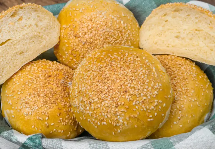 Koszyk pełen pysznych, złotych bułek bez drożdży, posypanych sezamem. Idealne na kanapki i burgery.