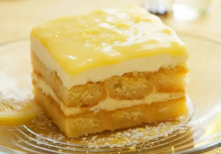 Pyszne tiramisu cytrynowe z warstwami biszkoptów i kremu, ozdobione cytrynową polewą.
