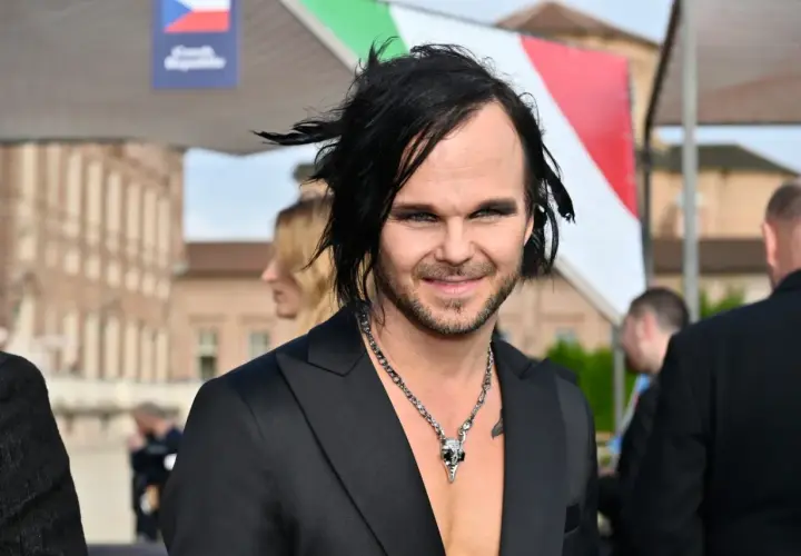 The Rasmus wokalista z charakterystyczną fryzurą i makijażem, w czarnym garniturze i naszyjnikiem z czaszką.