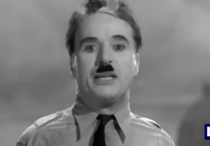 Charlie Chaplin, con baffi e camicia, ricorda il suo discorso in "Il grande dittatore", un film che gli valse un Oscar onorario.