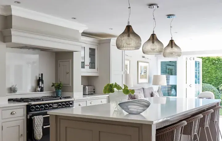 Elegant kitchen with island, dining area, and garden view. Showcasing latest kitchen designs with neutral tones and modern lighting.