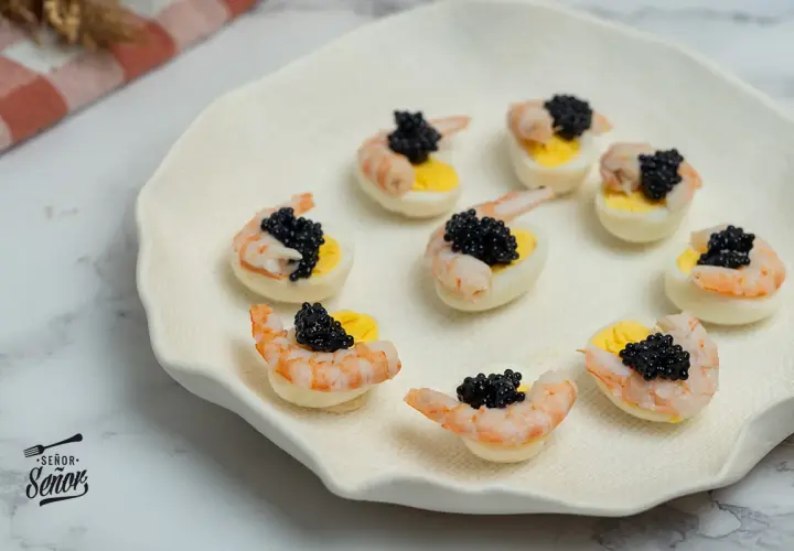Deliciosos canapés con huevos de codorniz, camarones y caviar negro. Un bocado elegante y sabroso.