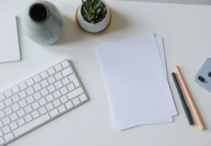 Schreibtisch mit Tastatur, Notizen, Stiften und Handy. Perfekt, um das Fernstudium zu organisieren und den Überblick zu behalten.