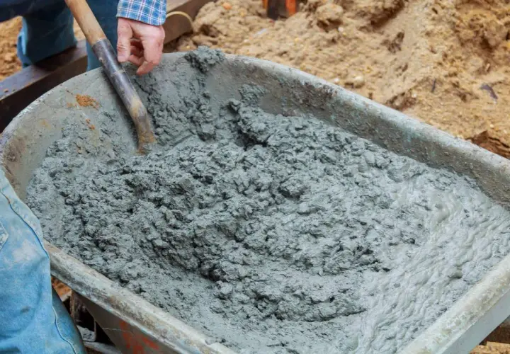 Mieszanie betonu B20 w taczce. Właściwe proporcje składników są kluczowe dla uzyskania wytrzymałego materiału budowlanego.