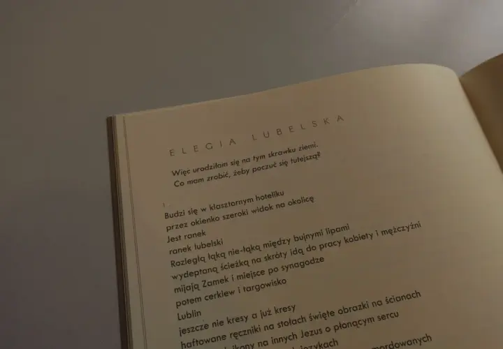 Otwarta książka z tekstem wiersza "Elegia Lubelska" Julii Hartwig.