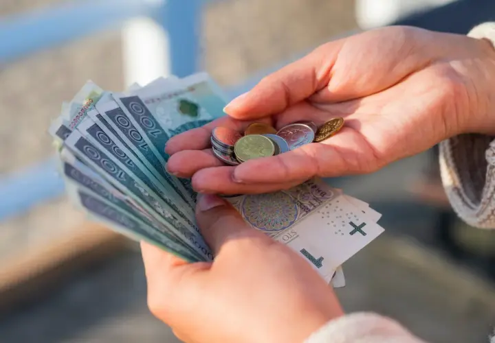 Dłonie liczą banknoty i monety. Czy to wystarczy na życie, gdy placa minimalna netto 2026 będzie obowiązywać?