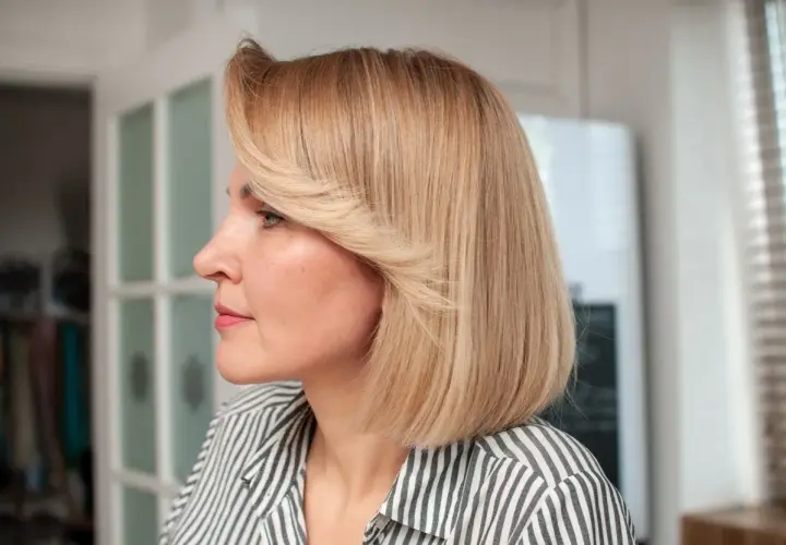Kobieta z blond włosami w stylu french bob, w paski.