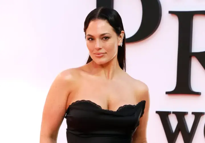 Ashley Graham posa con un vestido negro sin tirantes, luciendo elegante y segura.