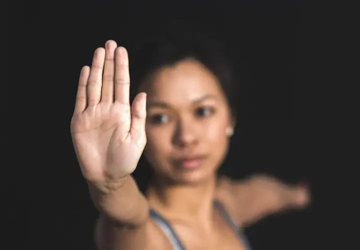 Dłoń uniesiona w geście "stop". Kobieta gotowa do obrony koniecznej, gdy sytuacja tego wymaga.