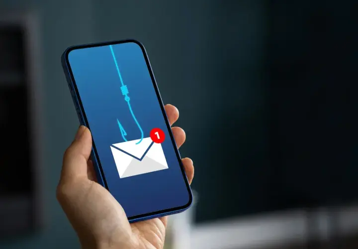 Telefon z ikoną koperty i haczykiem wędkarskim symbolizującym wyłudzenie pieniędzy. Uważaj na podejrzane wiadomości!