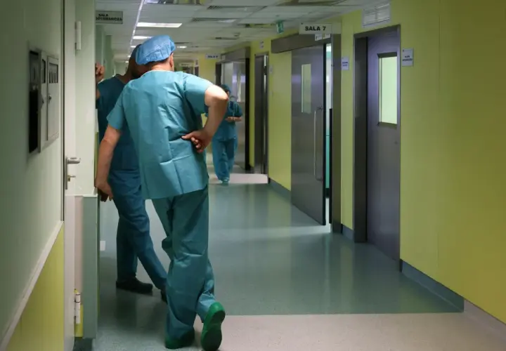 Lekarze w zielonych fartuchach idą korytarzem szpitalnym. Zastanawiasz się, ile zarabia lekarz?
