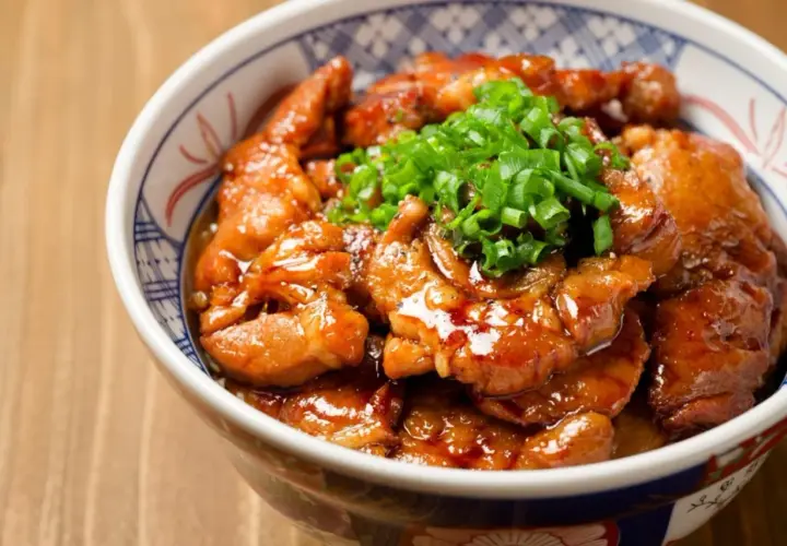 Miseczka z kurczakiem soboro w sosie teriyaki, posypana szczypiorkiem.