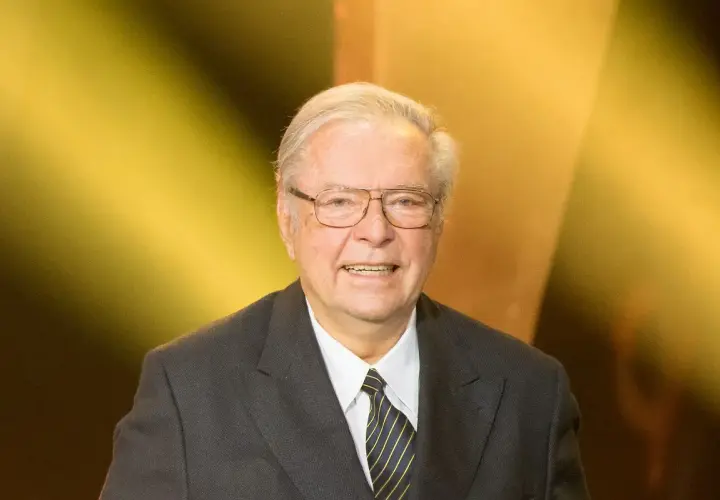 Uśmiechnięty Krzysztof Zanussi w garniturze, z okularami. Może opowiadać o swoich dzieciach.