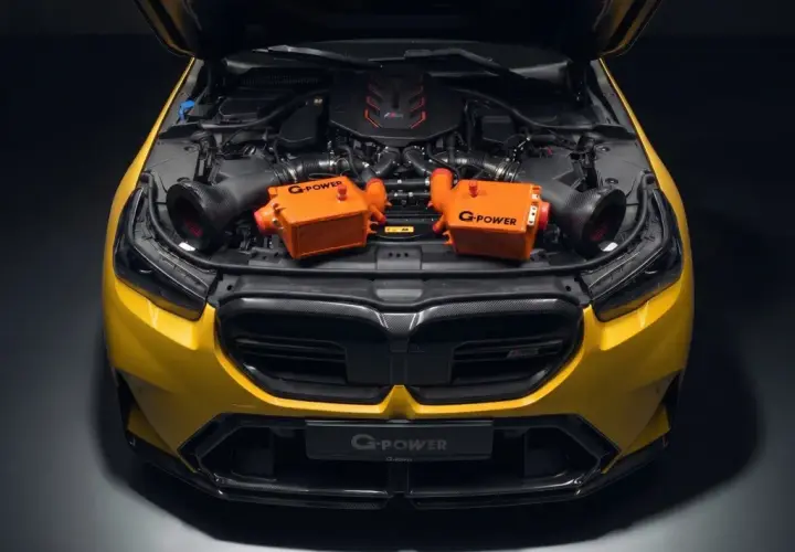 Żółte BMW M5 z otwartą maską, prezentujące dwa pomarańczowe intercoolery G-Power.
