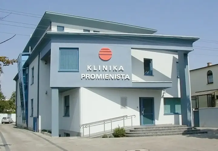 Nowoczesny budynek kliniki "Promienista" w Poznaniu z niebieskimi elementami i logo.