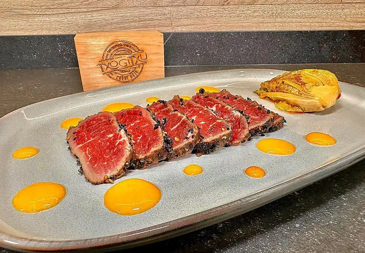 Tataki de ternera con costra de sésamo negro, acompañado de un toque de kimchi y salsa amarilla.